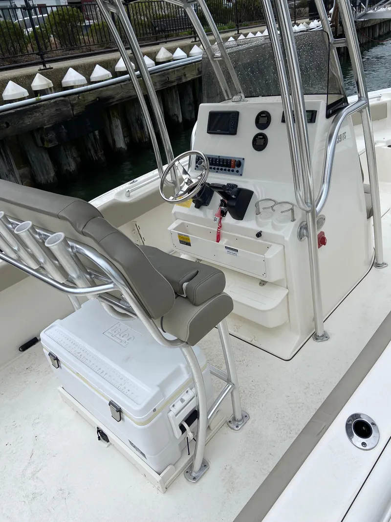 Slide: The Image of 2022 Key West 239 FS boat interior with helm, seating, and cooler. - 1