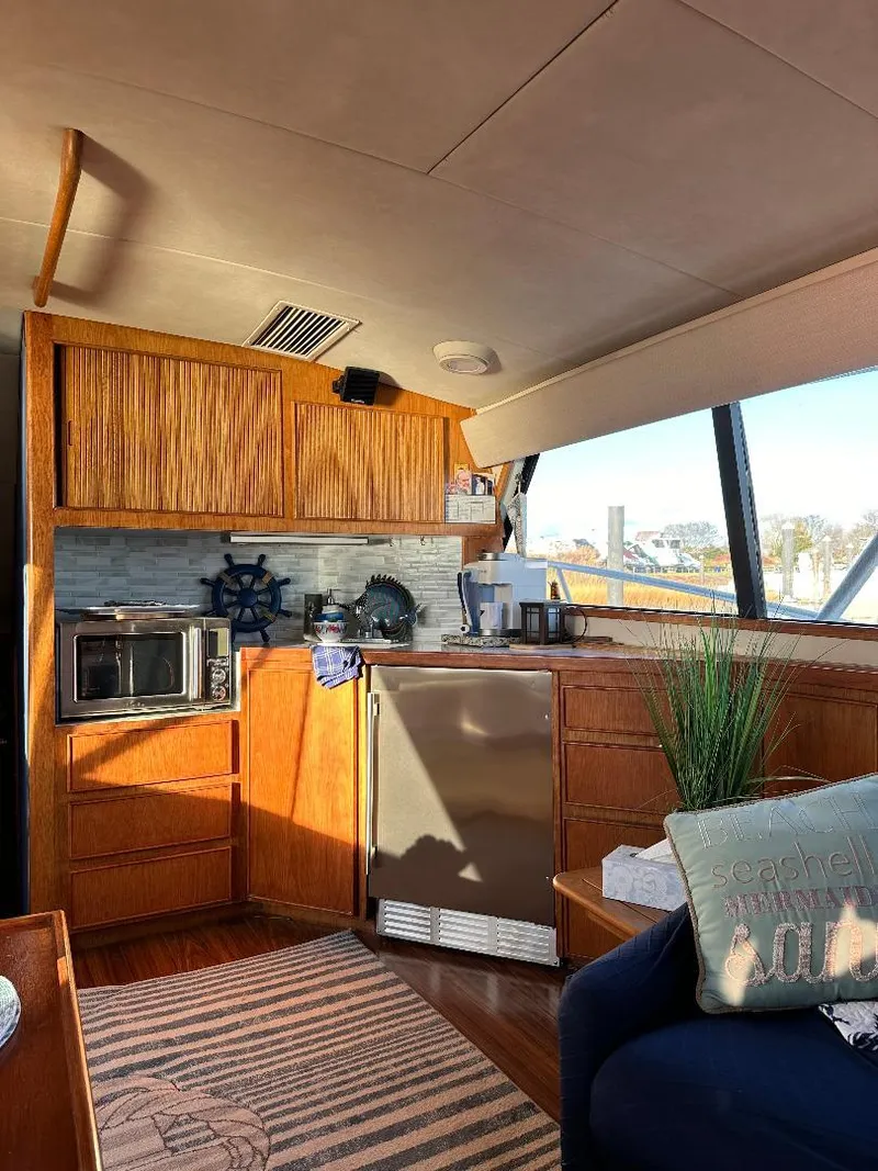 Slide: The Image of Interior of a 1989 Bertram 43 Convertible yacht with wooden cabinetry and modern appliances. - 16