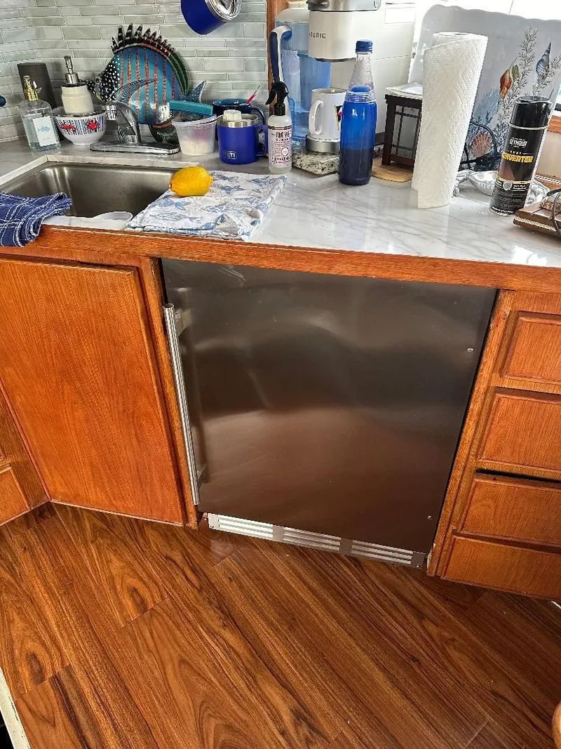 Slide: The Image of Kitchen area of a 1989 Bertram 43 Convertible yacht with wooden cabinets and stainless steel appliances. - 20