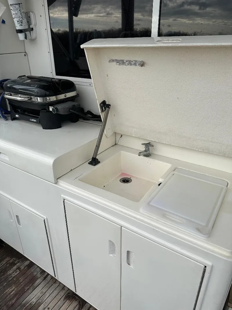 Slide: The Image of 1989 Bertram 43 Convertible yacht kitchen with sink and grill on deck. - 27