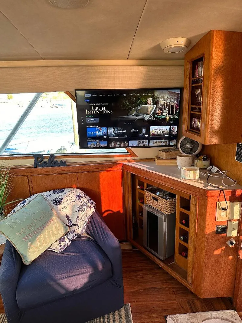 Slide: The Image of Interior of a 1989 Bertram 43 Convertible yacht with cozy seating and entertainment setup. - 4