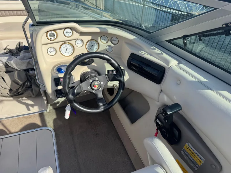 Slide: The Image of Interior of a 1998 Mariah 222 Shabah boat, featuring steering wheel and dashboard controls. - 10