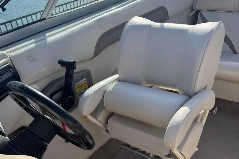 Slide: The Image of Interior of a 1998 Mariah 222 Shabah boat, featuring a white captain's chair and steering wheel. - 14