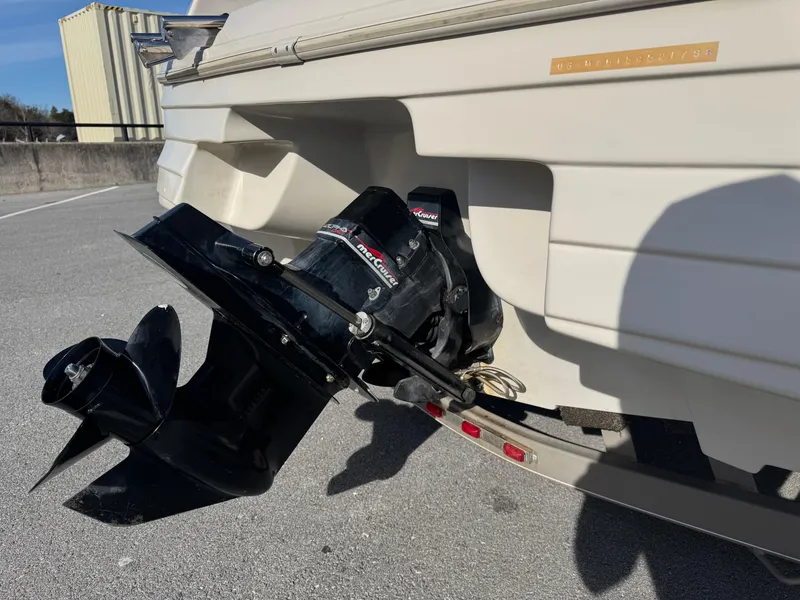 Slide: The Image of 1998 Mariah 222 Shabah boat stern with outboard motor on pavement. - 4