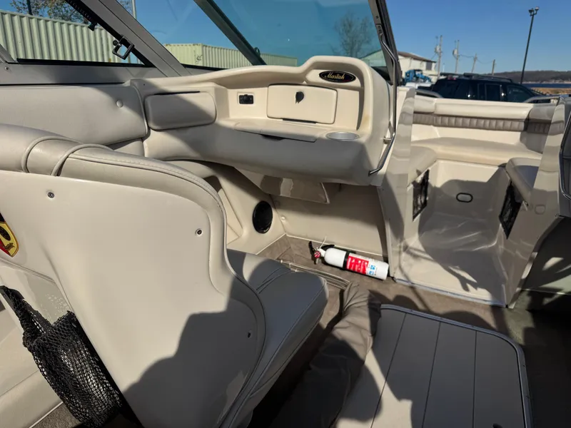 Slide: The Image of Interior of a 1998 Mariah 222 Shabah boat with beige seating and a fire extinguisher. - 7