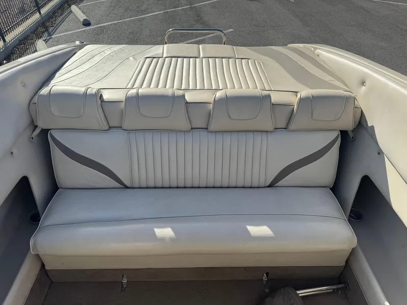 Slide: The Image of 1998 Mariah 222 Shabah boat interior with beige seating and stitching details. - 9