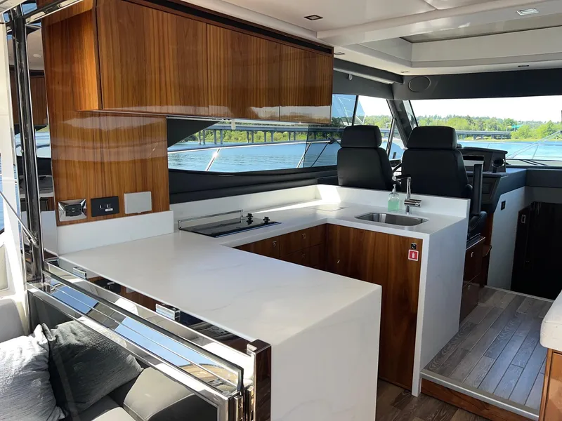Slide: The Image of Luxurious interior of 2023 Riviera 4600 Sport Yacht Platinum Edition with modern kitchen and seating. - 12