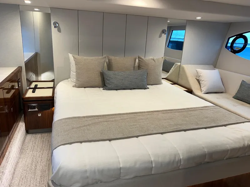 Slide: The Image of Luxurious bedroom in 2023 Riviera 4600 Sport Yacht Platinum Edition with elegant bedding and modern design. - 17