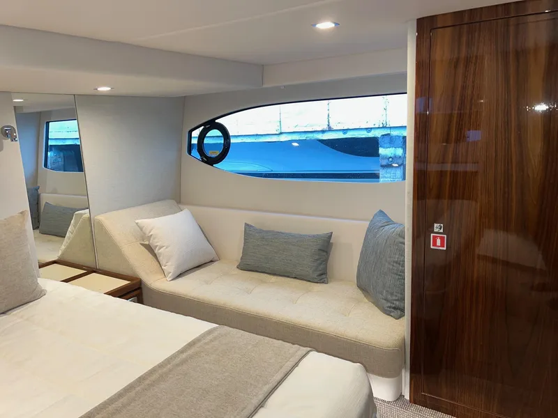 Slide: The Image of Luxurious interior of 2023 Riviera 4600 Sport Yacht Platinum Edition with elegant seating and bedding. - 18