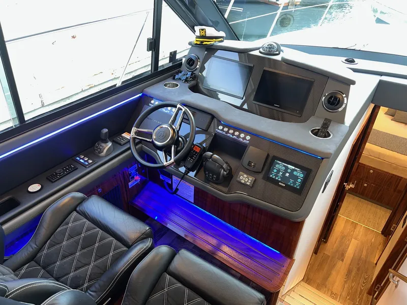 Slide: The Image of 2023 Riviera 4600 Sport Yacht Platinum Edition helm with modern controls and luxurious seating. - 6