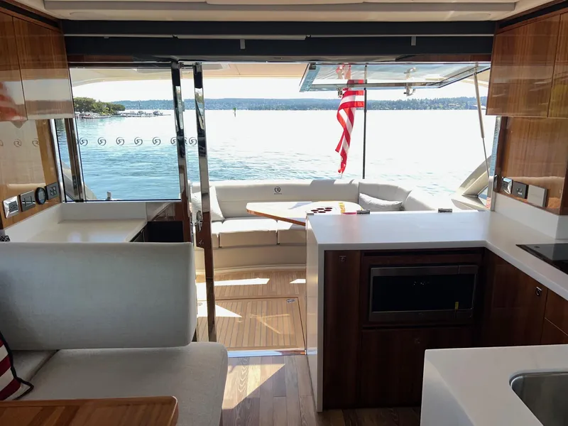 Slide: The Image of Interior of 2023 Riviera 4600 Sport Yacht Platinum Edition with lake view and modern furnishings. - 8