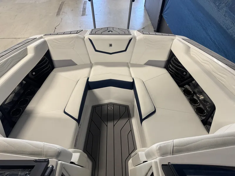 Slide: The Image of 2025 Nautique Super Air Nautique G23 boat interior with white seating and cup holders. - 14