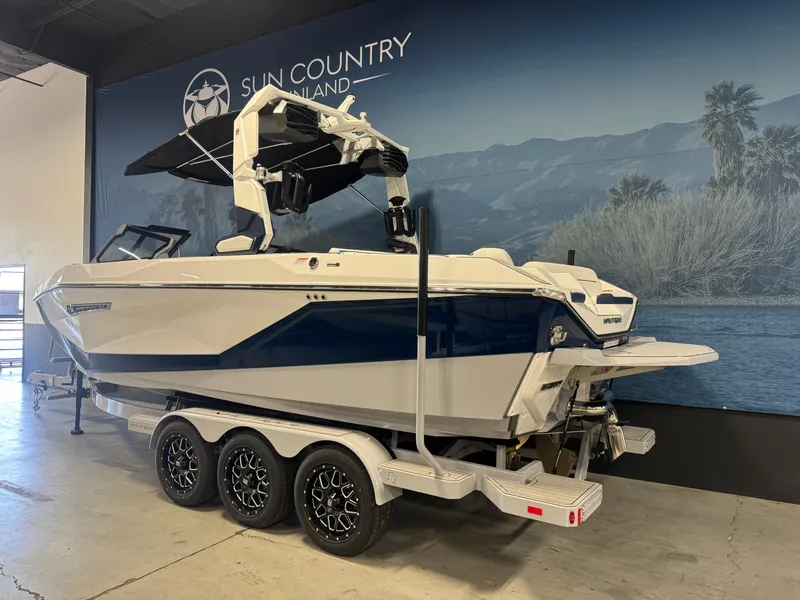Slide: The Image of 2025 Nautique Super Air Nautique G23 boat on a trailer in showroom. - 3