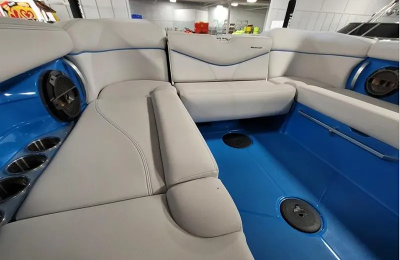 Slide: The Image of 2018 MasterCraft X26 boat interior with gray seating and blue flooring. - 10