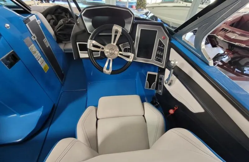 Slide: The Image of 2018 MasterCraft X26 boat interior with blue dashboard and modern steering wheel. - 7