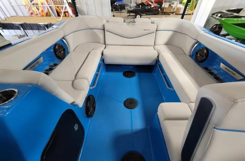Slide: The Image of 2018 MasterCraft X26 boat interior with blue flooring and gray seating. - 9