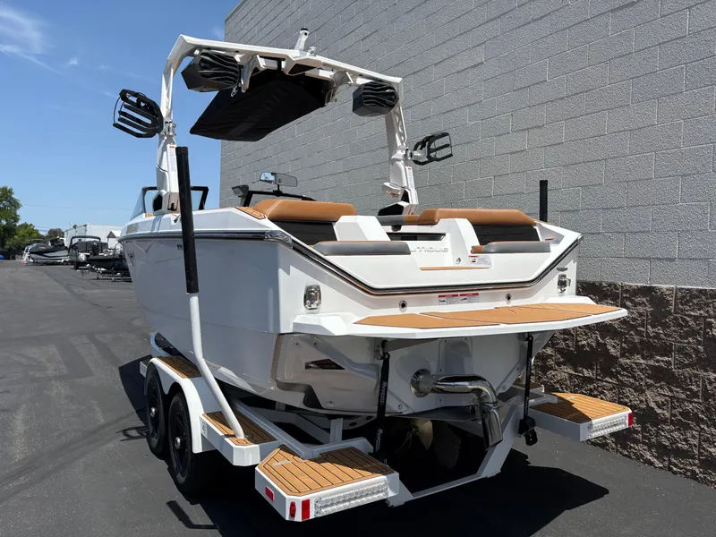 Slide: The Image of 2025 Nautique Super Air Nautique S21 boat on trailer, rear view, parked outdoors. - 2