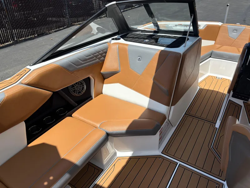 Slide: The Image of 2025 Nautique Super Air Nautique S21 interior with tan and gray seating, sleek design. - 8