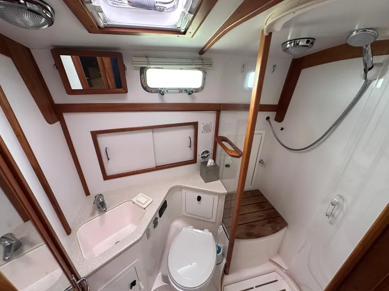 Slide: The Image of 2006 Sabre 42 Hard Top Express bathroom with shower, sink, and wooden accents. - 14