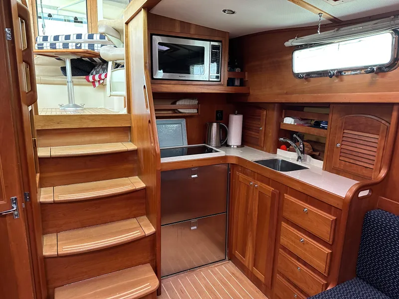 Slide: The Image of 2006 Sabre 42 Hard Top Express yacht interior with wooden cabinetry and compact kitchen. - 15