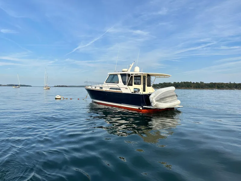 Slide: The Image of 2006 Sabre 42 Hard Top Express yacht on calm water under blue sky. - 2