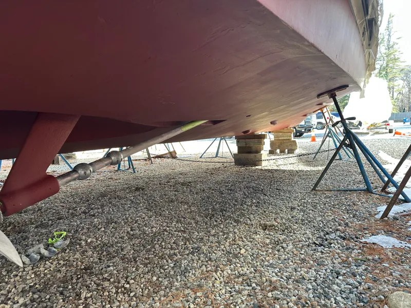 Slide: The Image of 2006 Sabre 42 Hard Top Express boat hull on stands, gravel ground. - 20