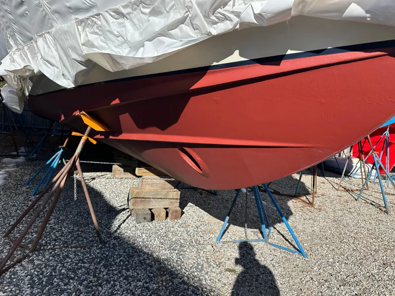 Slide: The Image of 2006 Sabre 42 Hard Top Express boat hull on stands, covered and stored outdoors. - 23