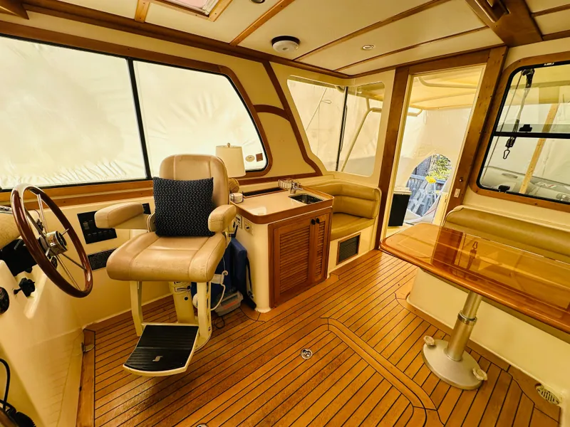 Slide: The Image of 2006 Sabre 42 Hard Top Express interior with helm, seating, and wooden flooring. - 3
