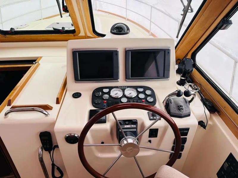 Slide: The Image of 2006 Sabre 42 Hard Top Express helm with dual screens and classic wooden steering wheel. - 8