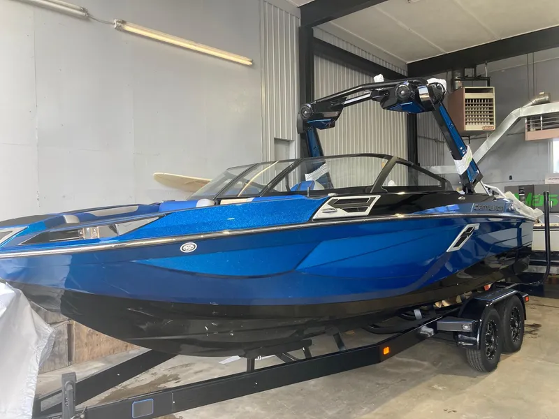 Slide: The Image of 2023 Centurion Ri230 boat in a garage, featuring a sleek blue design. - 0