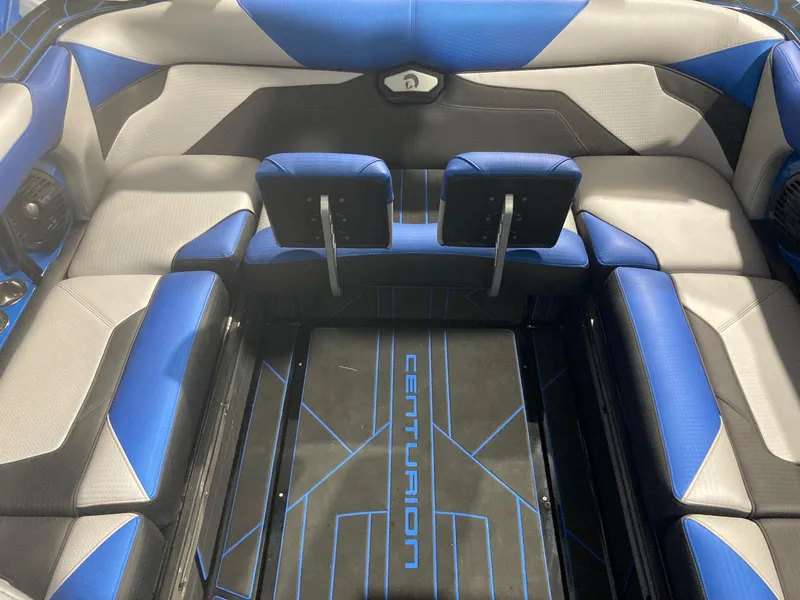 Slide: The Image of 2023 Centurion Ri230 boat interior with blue and gray seating and branded flooring. - 5