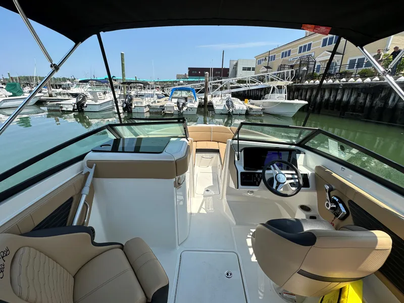 Slide: The Image of 2023 Sea Ray SPX 230 OB boat interior at marina, featuring modern helm and seating. - 4