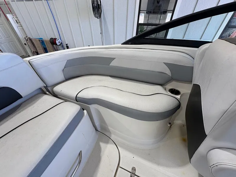 Slide: The Image of Interior seating of a 2017 SouthWind 2400 SD boat, featuring white and gray upholstery. - 11