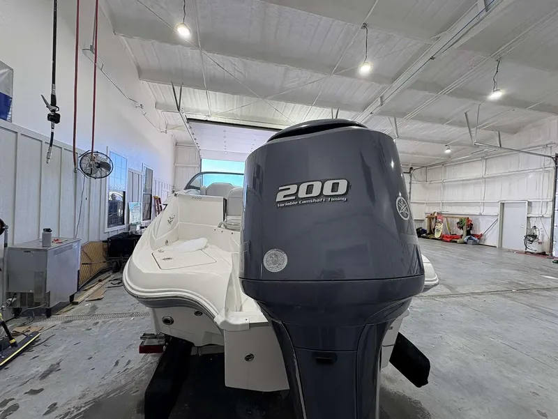 Slide: The Image of 2017 SouthWind 2400 SD boat with 200 horsepower engine in a spacious indoor facility. - 5