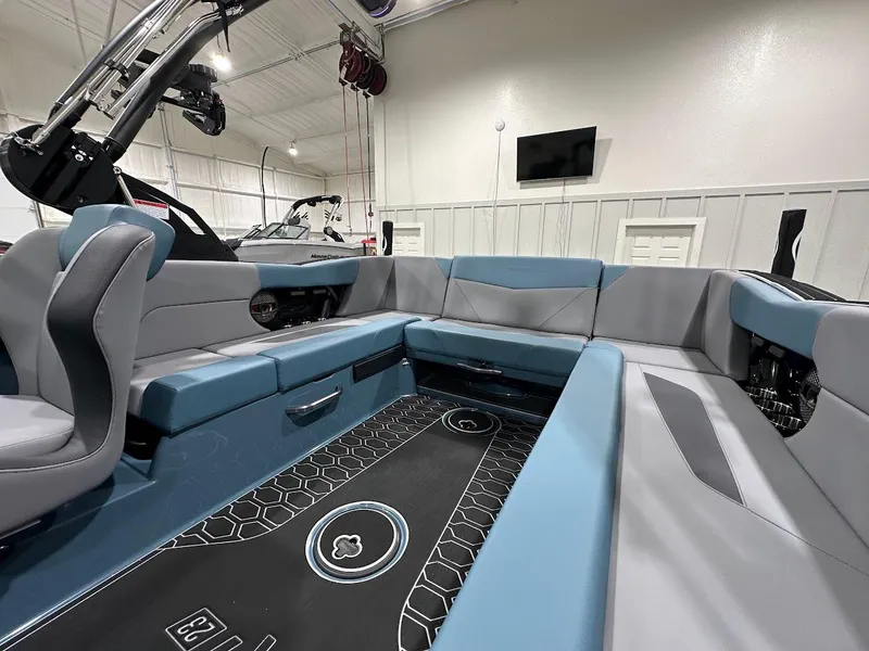 Slide: The Image of 2025 MasterCraft NXT23 boat interior with blue and gray seating, modern design, and spacious layout. - 10