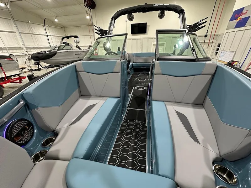 Slide: The Image of 2025 MasterCraft NXT23 boat interior with blue and gray seating, modern design, and spacious layout. - 13