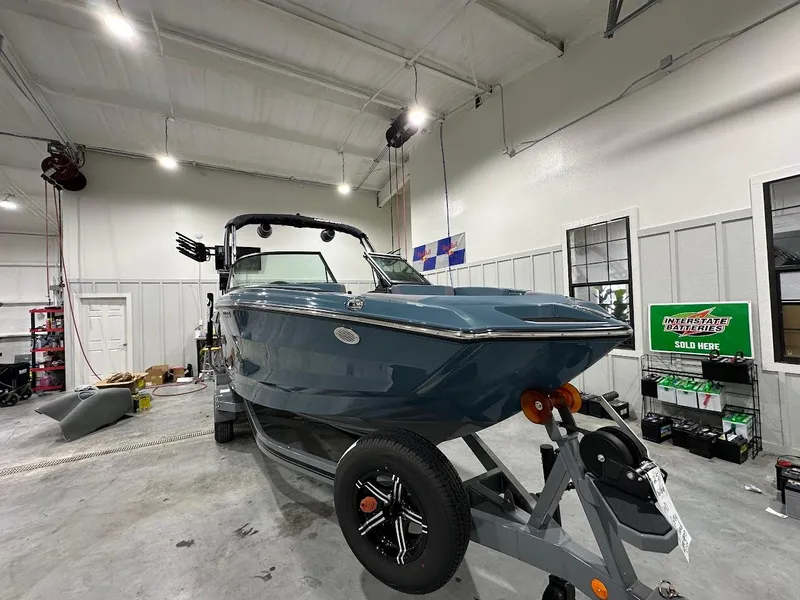 Slide: The Image of 2025 MasterCraft NXT23 boat in a garage, front view on trailer. - 5