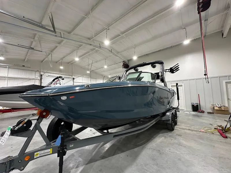 Slide: The Image of 2025 MasterCraft NXT23 boat in a spacious indoor showroom. - 6