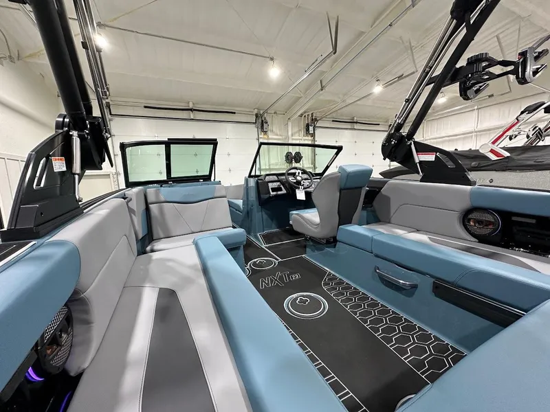 Slide: The Image of 2025 MasterCraft NXT23 boat interior with modern seating and sleek design in a spacious setting. - 8