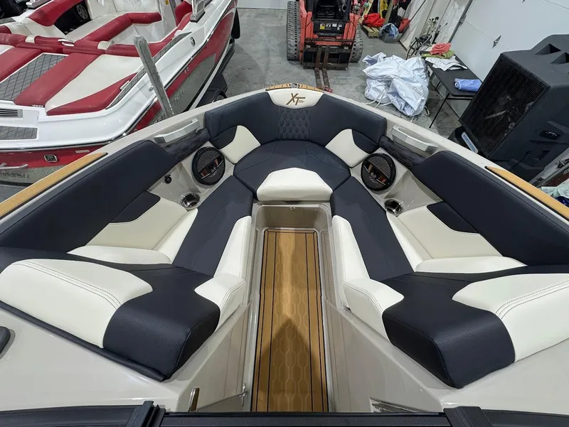 Slide: The Image of 2025 MasterCraft XT22 T boat on trailer in showroom, side view. - 14