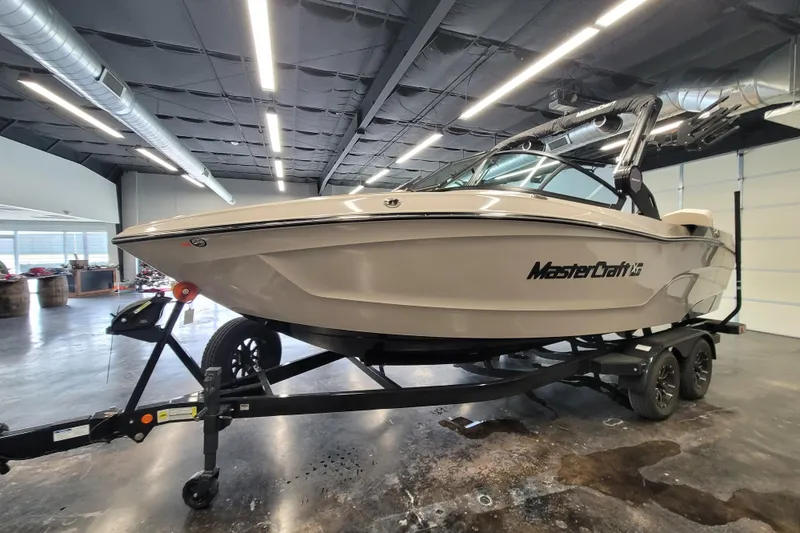 Slide: The Image of 2025 MasterCraft XT22 T boat on trailer in showroom setting. - 17