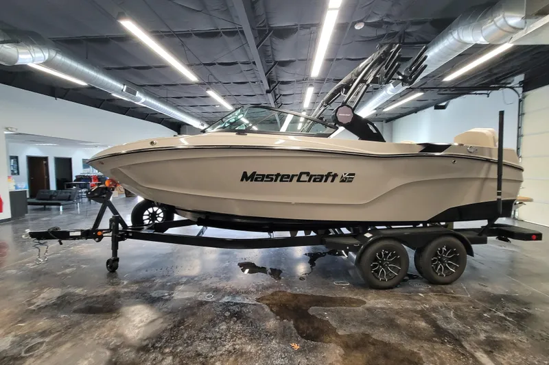 Slide: The Image of 2025 MasterCraft XT22 T boat on trailer in showroom setting. - 18