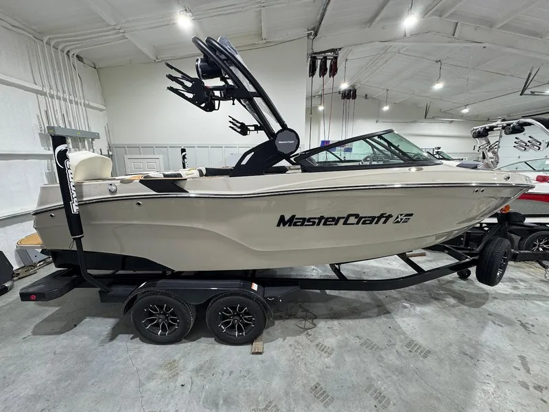 Slide: The Image of 2025 MasterCraft XT22 T boat on trailer in showroom, sleek design, modern features. - 6