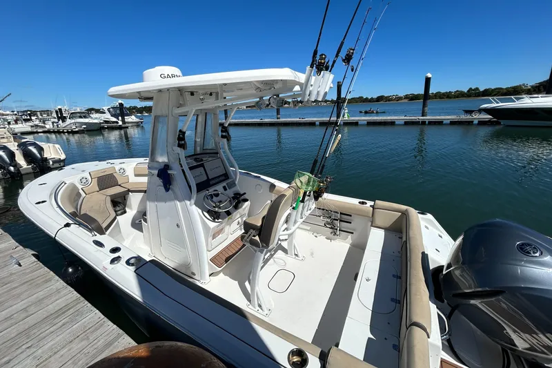 Slide: The Image of 2018 Tidewater 232 LXF boat docked, featuring fishing rods and a spacious deck. - 2