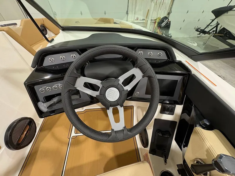 Slide: The Image of 2025 MasterCraft NXT24 boat dashboard with modern steering wheel and control panel. - 13