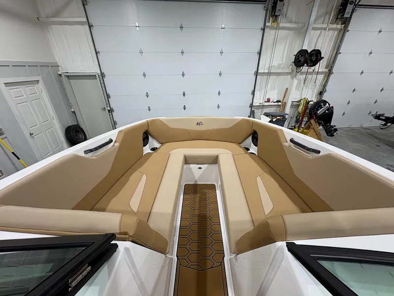 Slide: The Image of 2025 MasterCraft NXT24 boat interior with tan seating in a garage setting. - 14