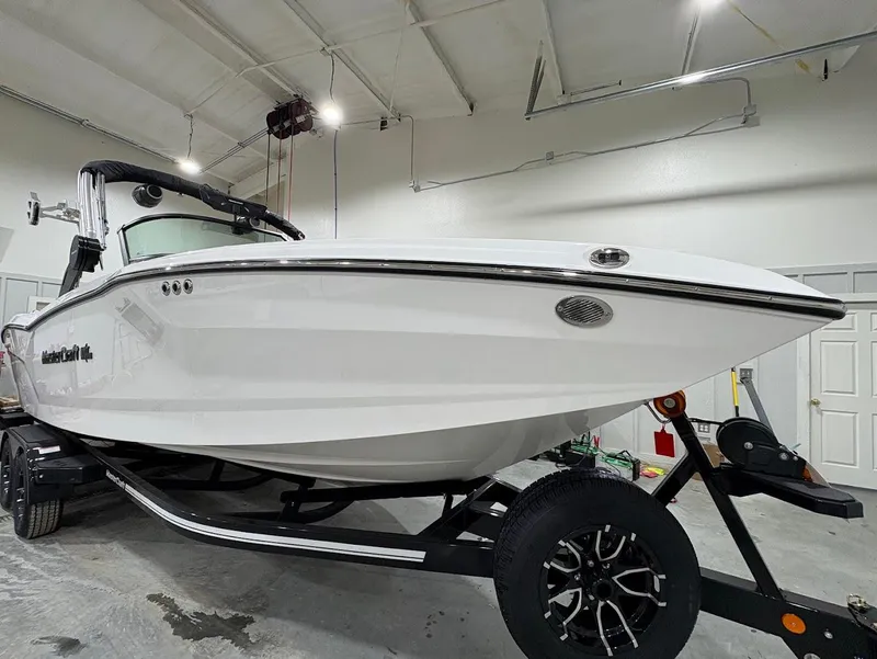 Slide: The Image of 2025 MasterCraft NXT24 boat on trailer in indoor storage facility. - 3