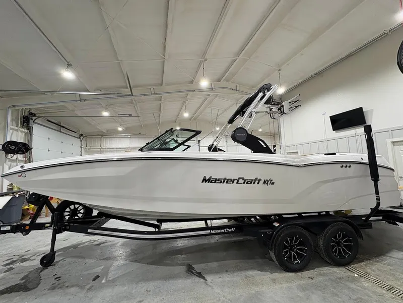 Slide: The Image of 2025 MasterCraft NXT24 boat in a garage, side view on a trailer. - 6