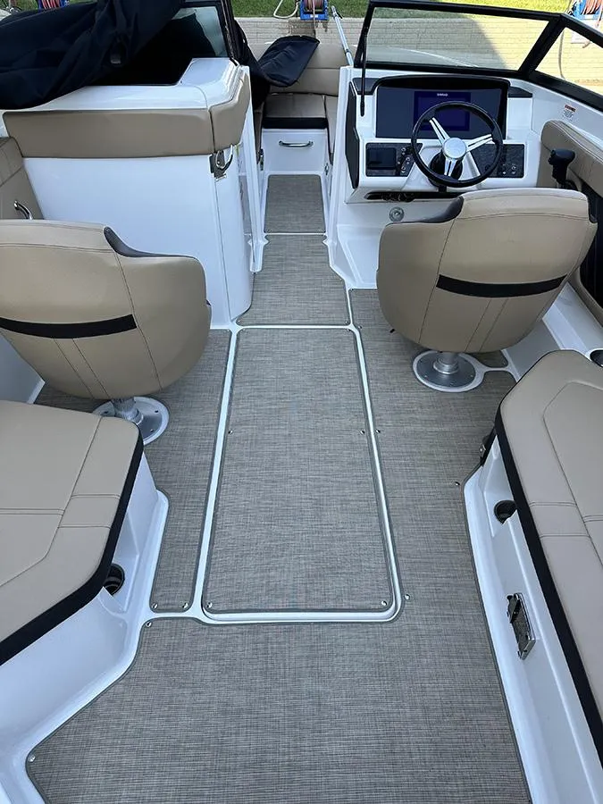 Slide: The Image of 2019 Sea Ray SPX 230 OB boat interior with beige seating and modern dashboard. - 10