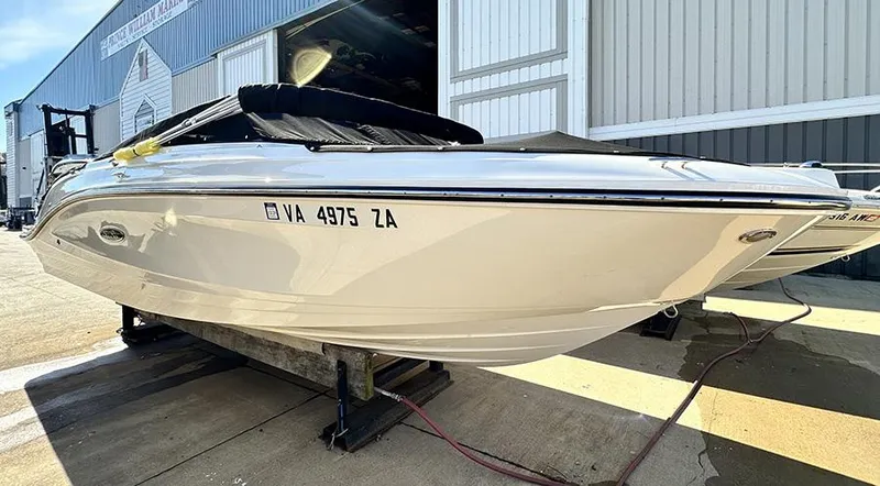 Slide: The Image of 2019 Sea Ray SPX 230 OB boat on a trailer, parked outside a warehouse. - 3